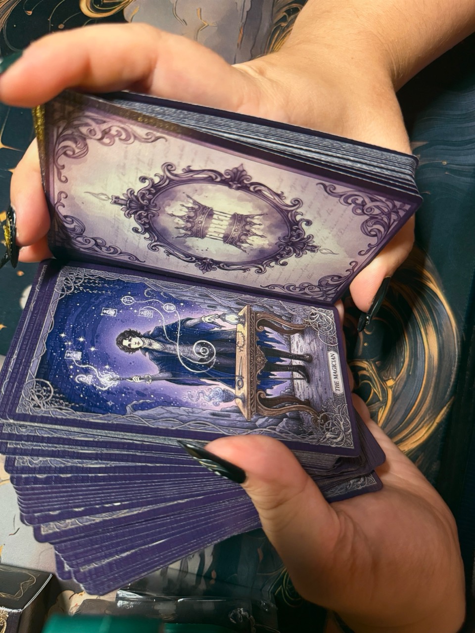 Queen's Folly deck held in both hands with The Magician card visible
